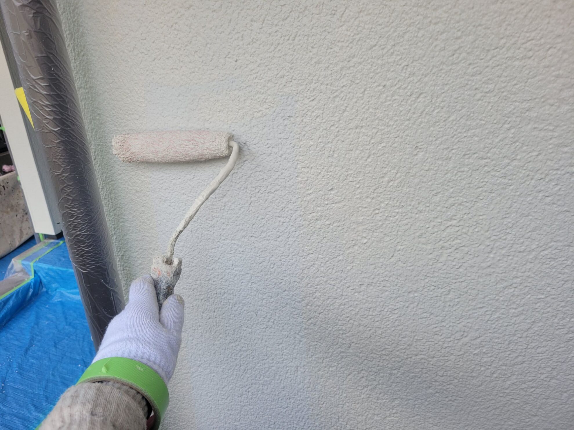 秦野市B様邸の外壁塗装工事で、モルタル壁に専用プライマーを使用した下塗り作業の様子