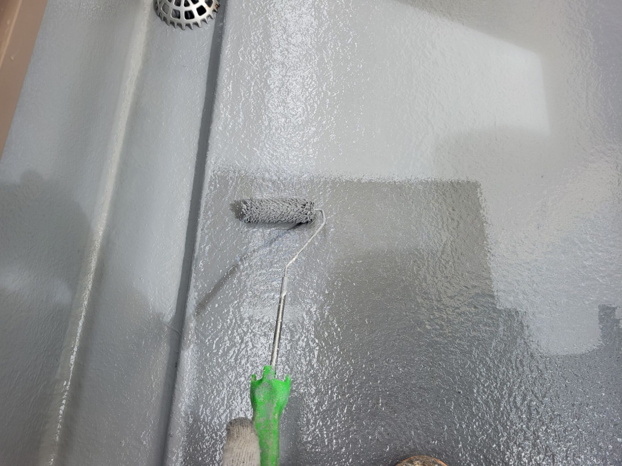 秦野市U様邸ベランダのトップコート2回目塗装中。ムラなく仕上げている職人作業