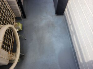 FRP防水の表面が退色し、白っぽく粉を吹いたように見える塗装前のベランダ床