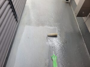 ベランダFRP防水の下地にプライマーを塗布して密着性を高める作業中の様子