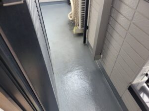 FRP床へ均一にプライマーを塗り広げる職人の手元。塗膜の密着を強化する工程