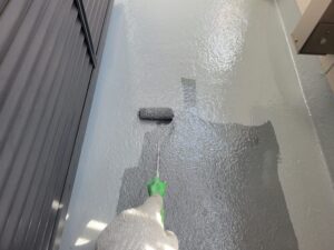 FRP防水層にトップコートを丁寧に塗装中。光沢のある美しい仕上がりを目指す工程