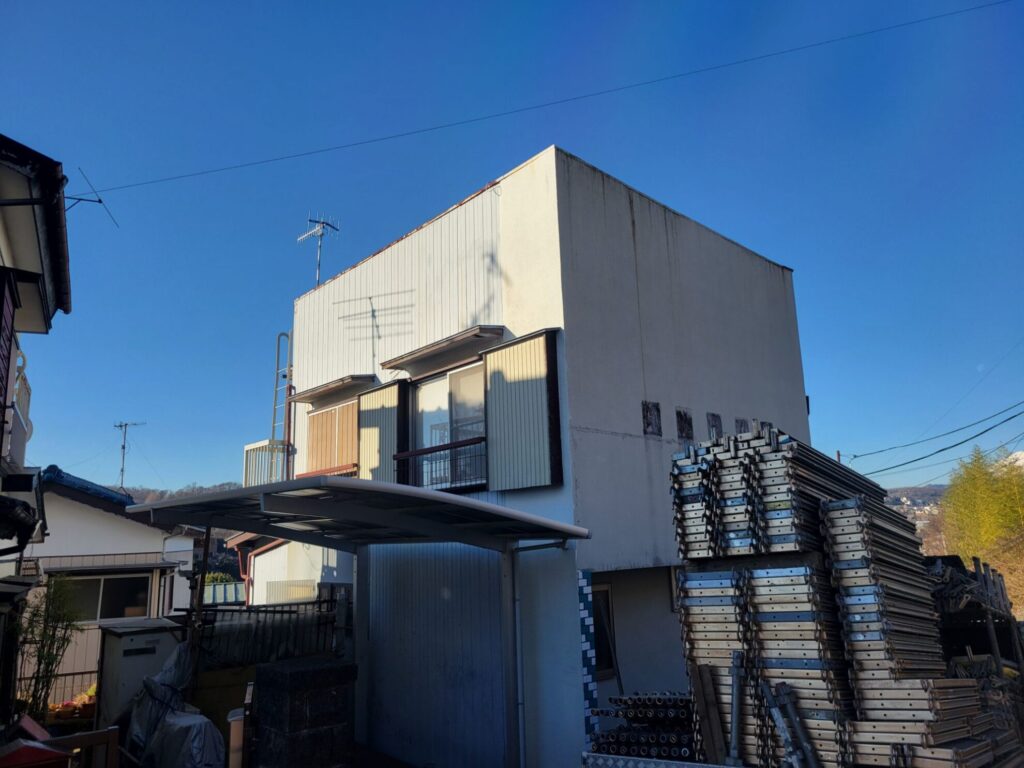 秦野市K様邸で外壁塗装工事に伴う足場設置作業を行っている様子