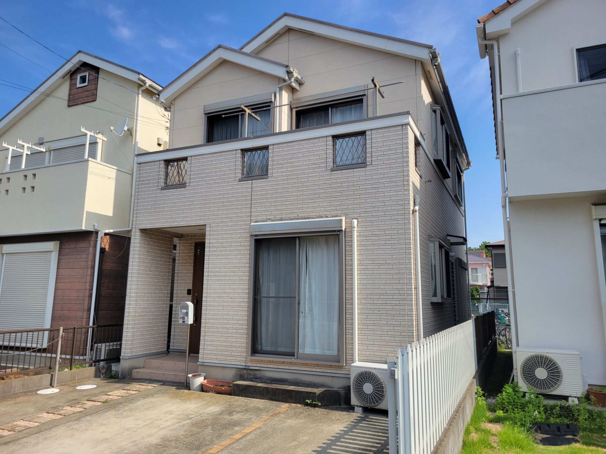 平塚市の外壁塗装工事で施工前の住宅外観を確認している様子