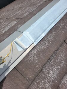 平塚市F様邸の棟板金に錆止めを塗装している様子