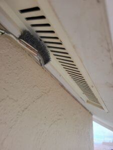 平塚市F様邸で換気口の表面をケレンしている様子
