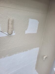 平塚市F様邸で外壁の中塗りを行っている様子