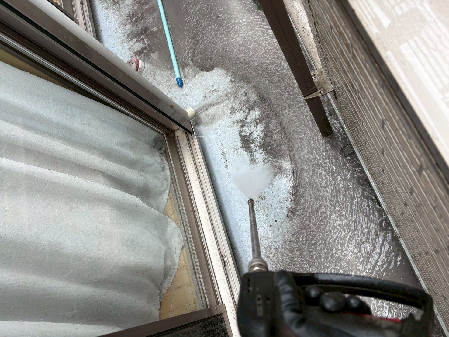 平塚市F様邸でベランダ床面を高圧洗浄している様子
