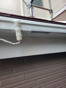 平塚市F様邸の破風板と鼻隠しまわりを上塗りしている様子