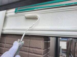 平塚市F様邸の帯板へ仕上げ塗料を重ねている様子